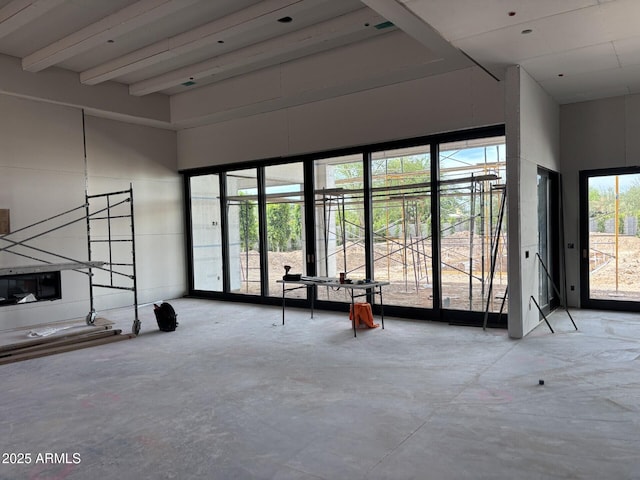 6426 E Turquoise Ave, Paradise Valley, AZ 85253 - unfurnished living room with unfinished concrete flooring, a high ceiling, and beamed ceiling