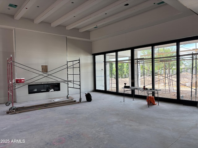 6426 E Turquoise Ave, Paradise Valley, AZ 85253 - unfurnished living room featuring beam ceiling, concrete flooring, and a towering ceiling