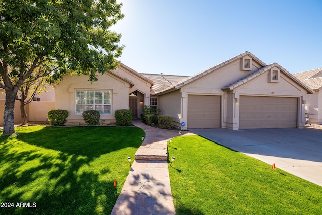 ranch-style home featuring a garage and a front lawn