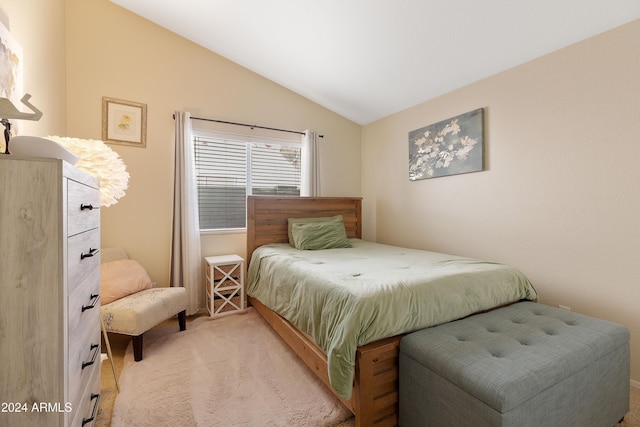 bedroom featuring light colored carpet and lofted ceiling