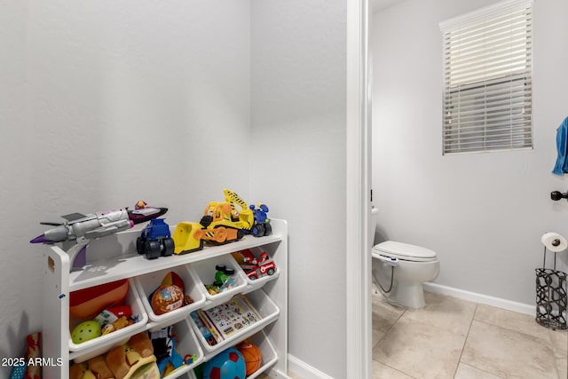 bathroom featuring toilet, tile patterned flooring, and baseboards