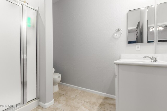 full bathroom featuring a stall shower, vanity, toilet, tile patterned floors, and baseboards