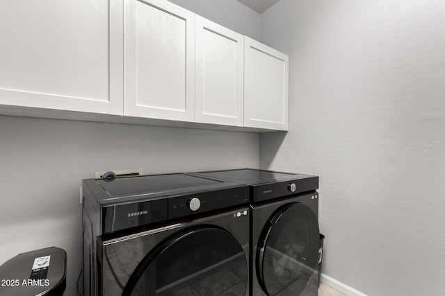laundry area with cabinet space, independent washer and dryer, and baseboards