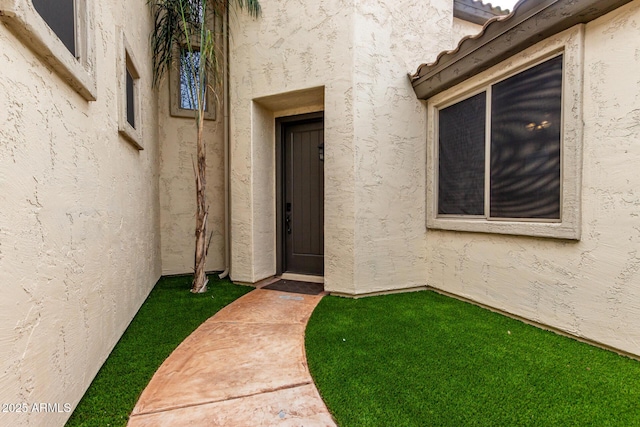view of exterior entry featuring stucco siding