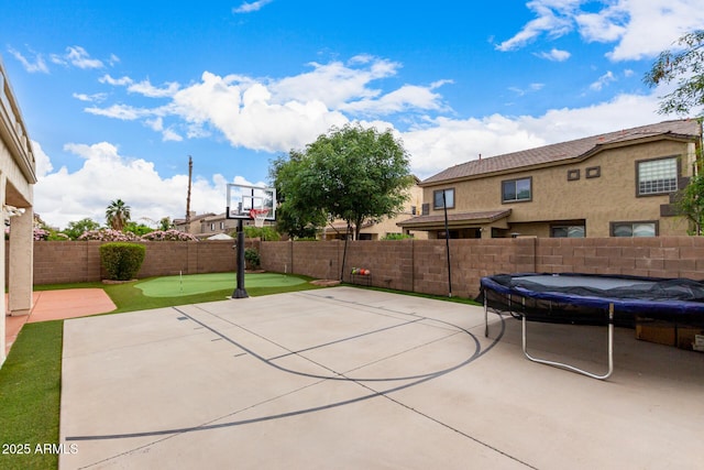 view of sport court with a fenced backyard, basketball court, and a swimming pool