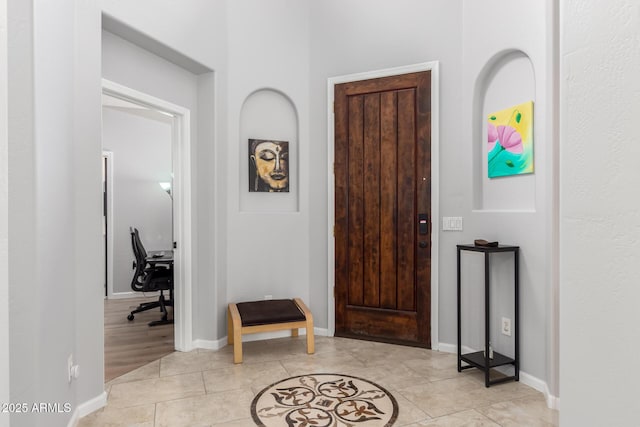 foyer entrance with baseboards and light tile patterned floors