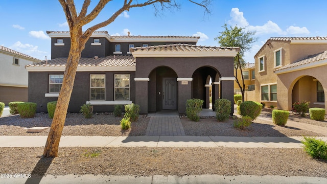 mediterranean / spanish-style house with a tile roof and stucco siding