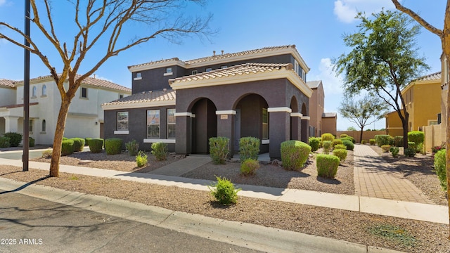 mediterranean / spanish-style home featuring a tile roof and stucco siding