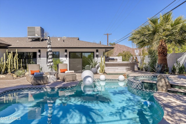 view of pool featuring a pool with connected hot tub, fence, central AC, and a patio