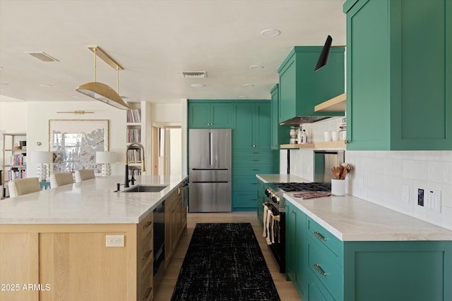 kitchen with high end appliances, a sink, visible vents, and decorative backsplash