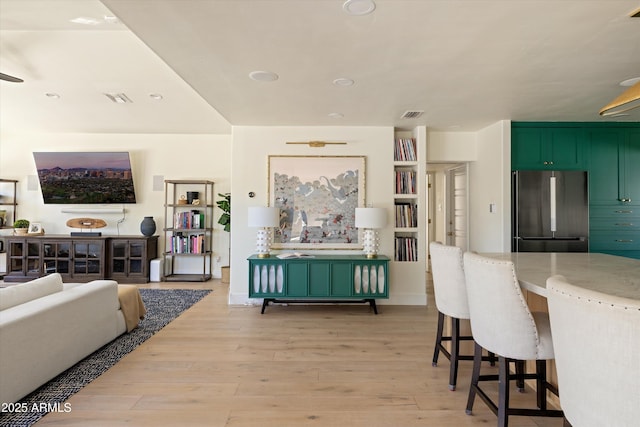 living area featuring light wood-style flooring, visible vents, and recessed lighting