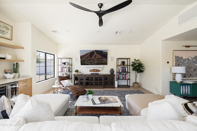 living room with lofted ceiling, visible vents, and baseboards