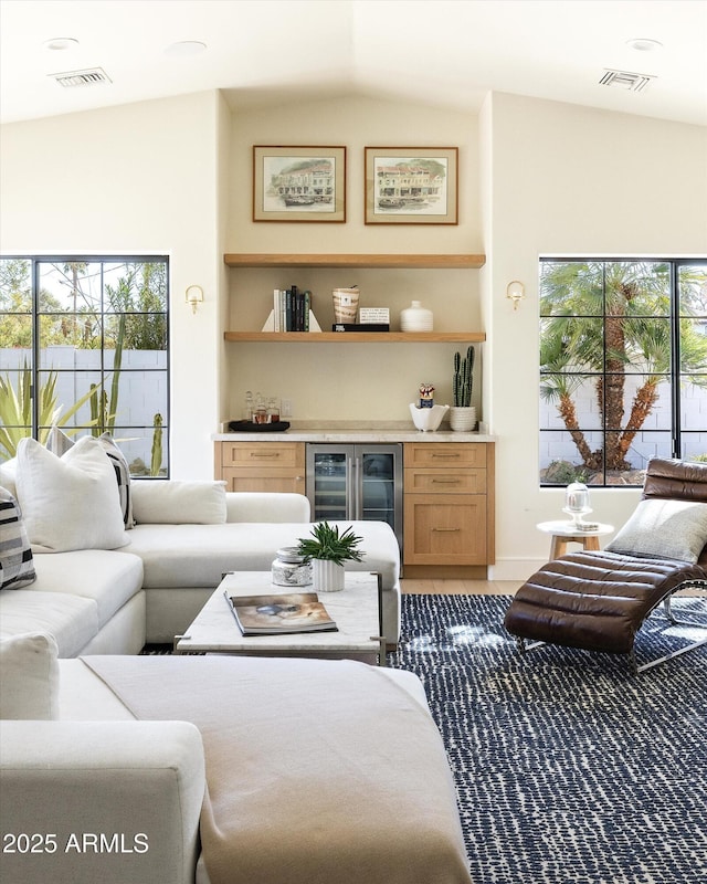 living room with a healthy amount of sunlight, visible vents, and a dry bar