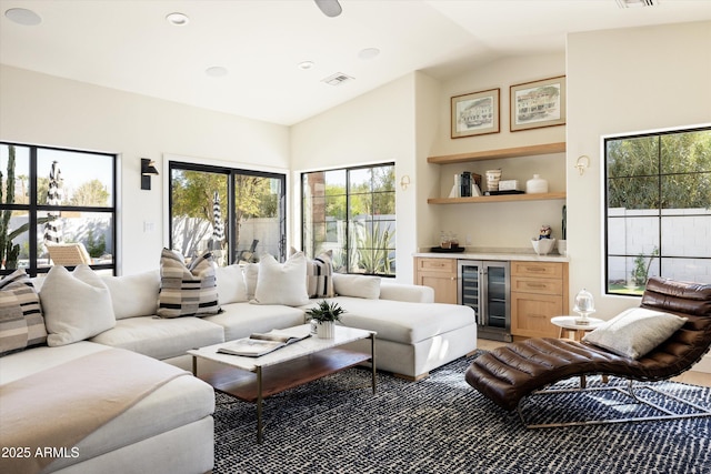 living area with vaulted ceiling, wine cooler, a dry bar, and visible vents