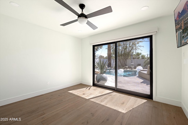 empty room with ceiling fan, baseboards, and hardwood / wood-style flooring