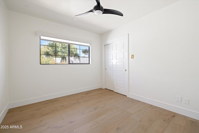 empty room with light wood-type flooring, ceiling fan, and baseboards