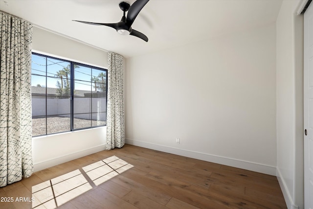 spare room with ceiling fan, baseboards, and wood finished floors