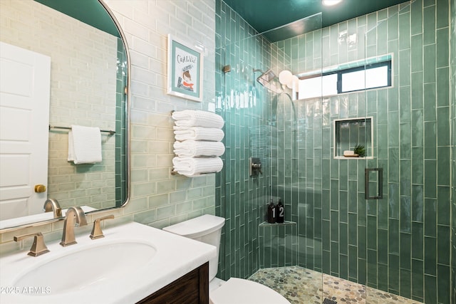 full bath featuring vanity, a shower stall, toilet, and tile walls