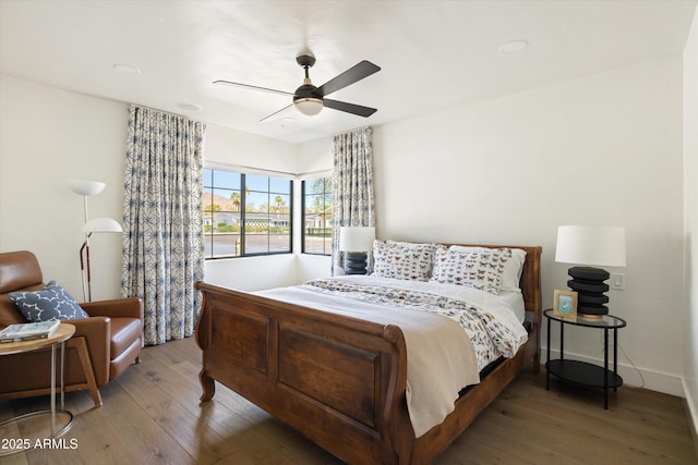 bedroom with wood-type flooring, ceiling fan, and baseboards