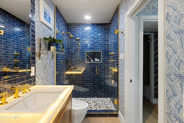 bathroom featuring vanity, wood finished floors, a shower stall, and toilet