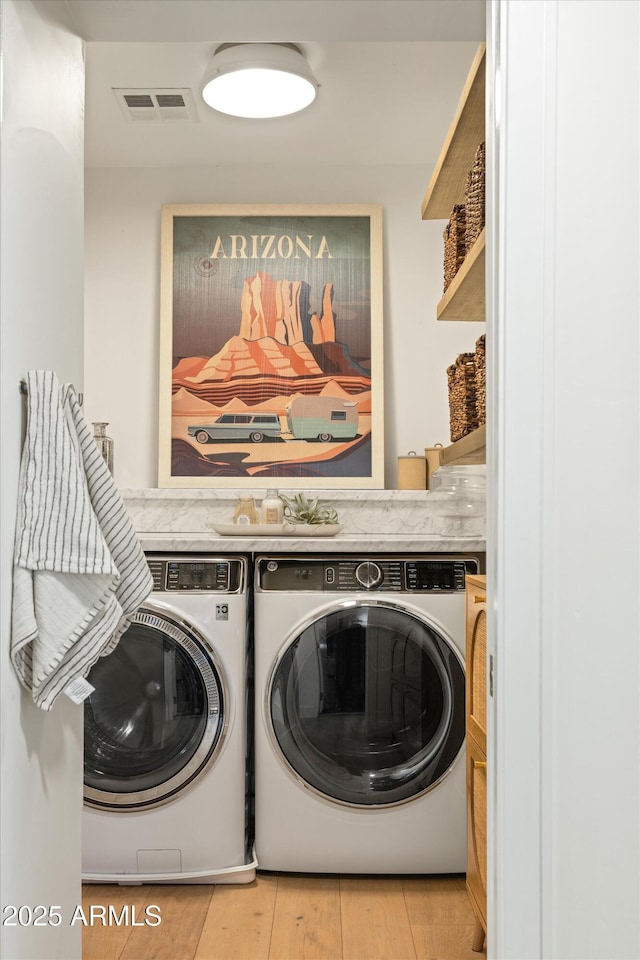 washroom with laundry area, visible vents, independent washer and dryer, and wood finished floors