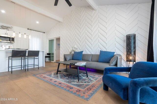 living room featuring ceiling fan and vaulted ceiling with beams