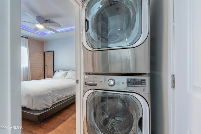 washroom featuring hardwood / wood-style flooring, ceiling fan, and stacked washer and dryer