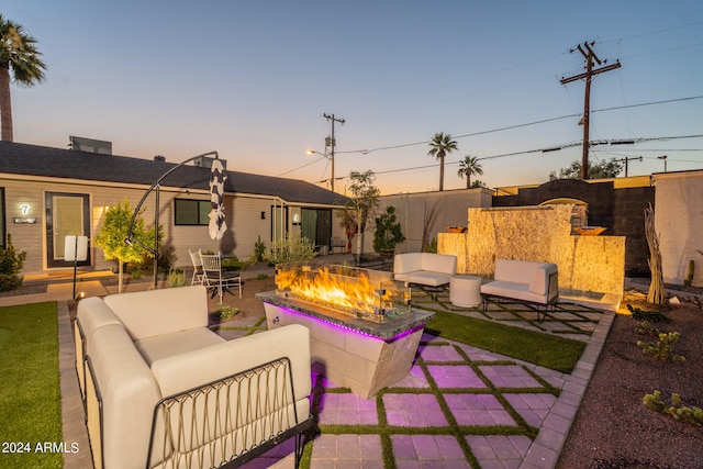 patio terrace at dusk featuring an outdoor living space with a fire pit