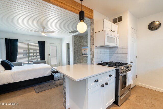 kitchen featuring pendant lighting, high end stove, kitchen peninsula, ceiling fan, and white cabinets