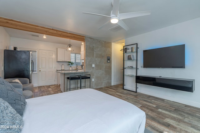 bedroom featuring tile walls, ceiling fan, hardwood / wood-style flooring, and stainless steel refrigerator