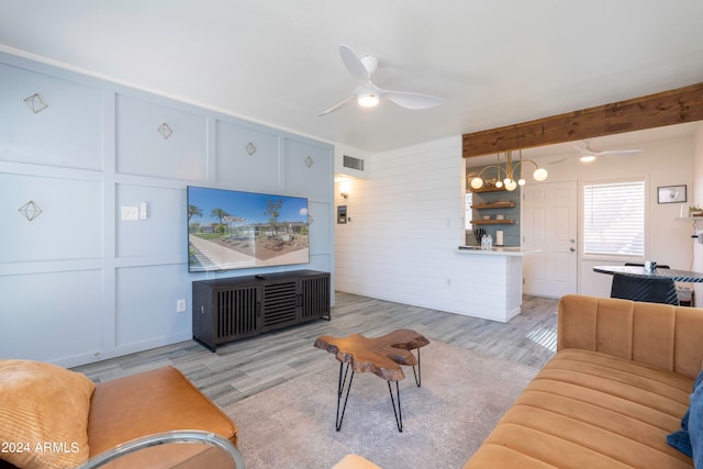 living room with ceiling fan, beamed ceiling, and light hardwood / wood-style floors