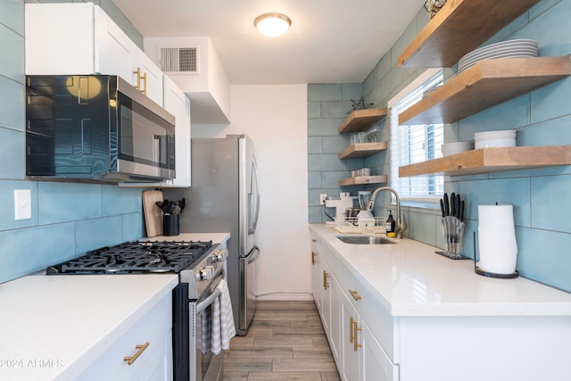 kitchen featuring white cabinets, stainless steel appliances, light hardwood / wood-style floors, and sink