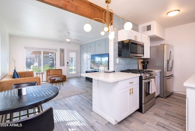 kitchen with light hardwood / wood-style flooring, decorative light fixtures, appliances with stainless steel finishes, and white cabinets