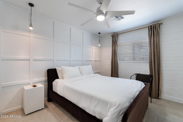 tiled bedroom featuring ceiling fan