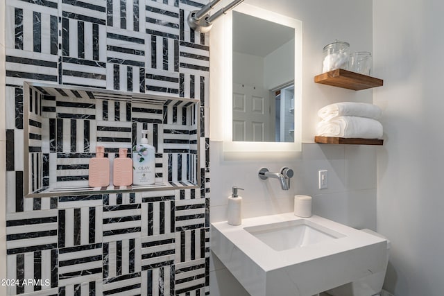 bathroom with tasteful backsplash and sink