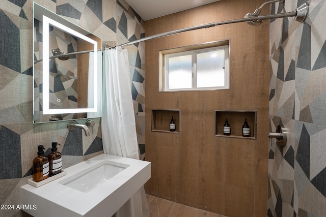 bathroom with curtained shower, sink, and tile patterned floors