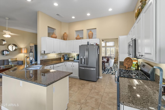 kitchen with light tile patterned floors, white cabinetry, kitchen peninsula, appliances with stainless steel finishes, and sink