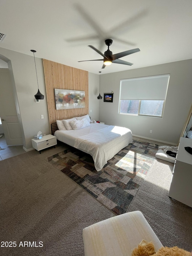 bedroom with visible vents, carpet floors, baseboards, and a ceiling fan