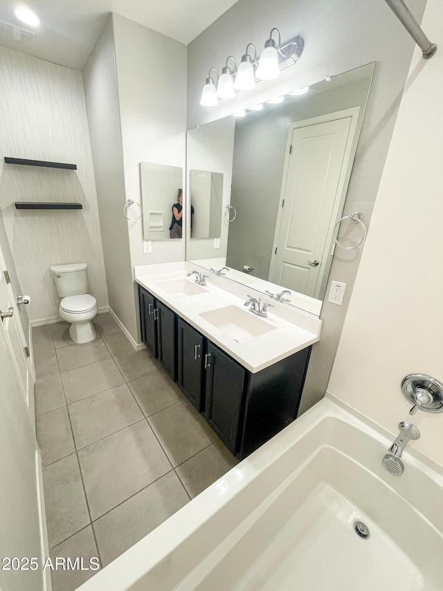 full bathroom featuring a sink, toilet, double vanity, and tile patterned floors