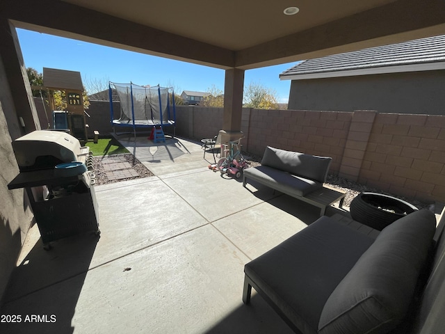 view of patio / terrace with a fenced backyard, grilling area, an outdoor hangout area, and a trampoline