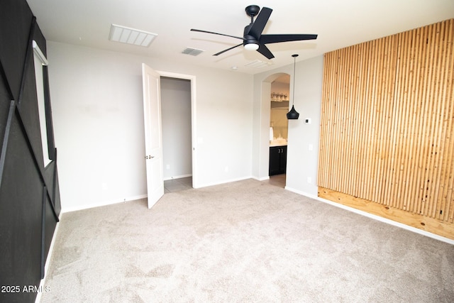 20471 E Carriage Way, Queen Creek, AZ 85142 - unfurnished bedroom with carpet flooring, arched walkways, baseboards, connected bathroom, and a ceiling fan