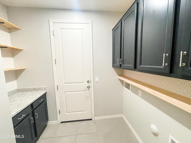 interior space with light tile patterned flooring, cabinet space, and baseboards