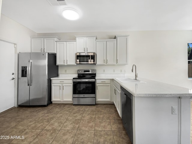 4229 E Betsy Ln, Gilbert, AZ 85296 - kitchen with appliances with stainless steel finishes, light countertops, white cabinetry, a peninsula, and light tile patterned floors