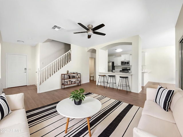 4229 E Betsy Ln, Gilbert, AZ 85296 - living area with stairway, a ceiling fan, wood finished floors, and arched walkways