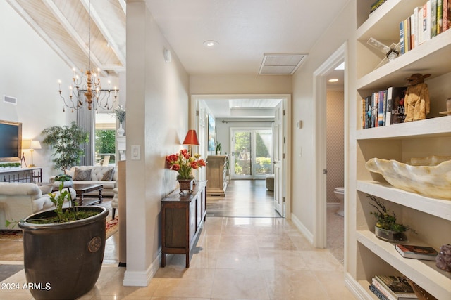 hallway with built in features and a notable chandelier