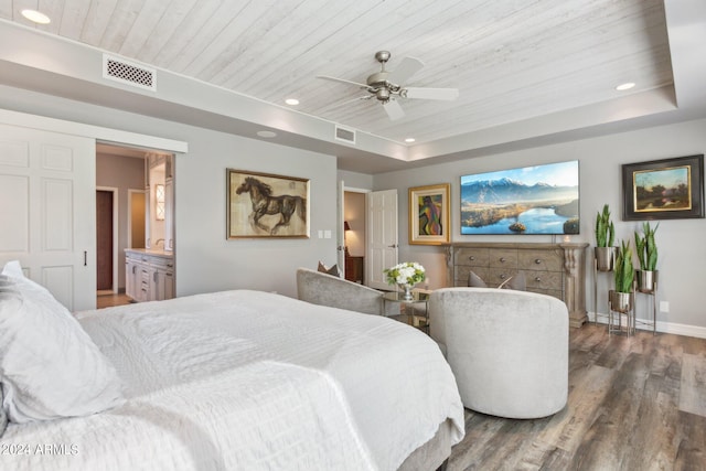 bedroom featuring dark hardwood / wood-style flooring, ensuite bathroom, wood ceiling, a raised ceiling, and ceiling fan