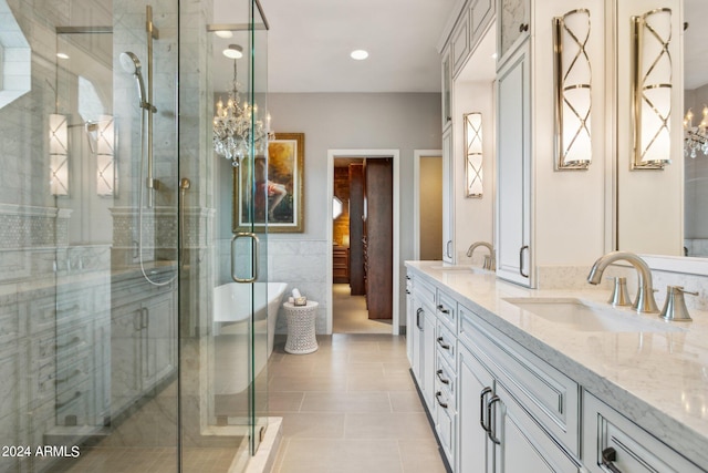 bathroom with tile patterned flooring, vanity, a notable chandelier, and shower with separate bathtub