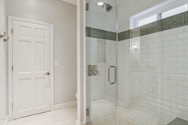 bathroom with tile patterned flooring and a shower with shower door