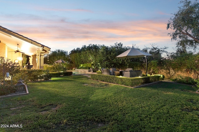 yard at dusk featuring area for grilling