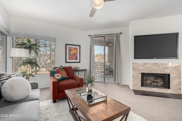 carpeted living room featuring ceiling fan, a tile fireplace, and a healthy amount of sunlight